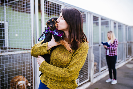 woman holding dog at a shelter