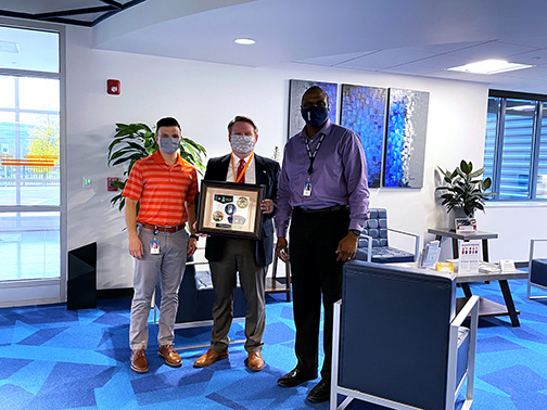 Community Development Manager, Timothy Strong, stands with Visions President/CEO, Tyrone Muse, as they accept a plaque from the Baden-Powell Council of the Boy Scouts of America.