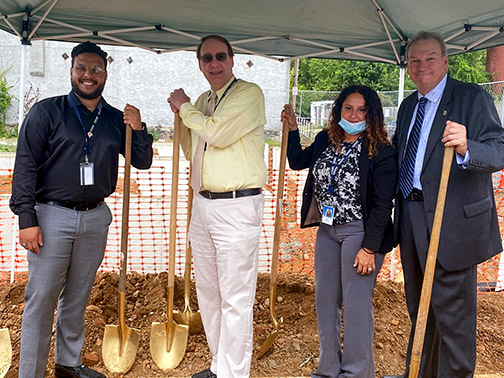 Visions Community Development Liaison of PA, Gustavo, poses with members of the Berks County Habitat for Humanity wielding golden shovels.