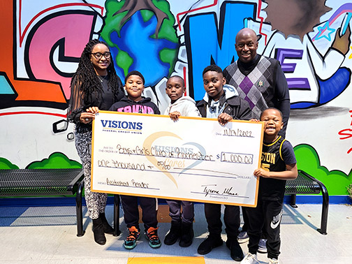 Members of the Boys & Girls Club of Rochester, NY pose with a jumbo Visions Cares grant check for their Accelerated Reading Program.