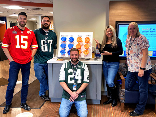 Staff at our Binghamton East branch office show off their blue and orange punch board game for members.