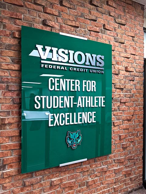 A photo of the sign for the newly renovated Center for Student-Athlete Excellence at Binghamton University, which features the Visions logo.