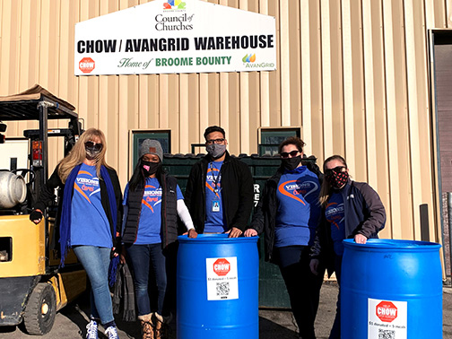 After volunteering, employees from the Visions Cares team stand with CHOW donation barrels outside Broome County Council of Churches.