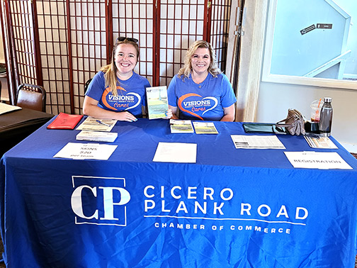 Visions employees smile at the volunteer table during the Cicero Plank Road Golf Tournament.