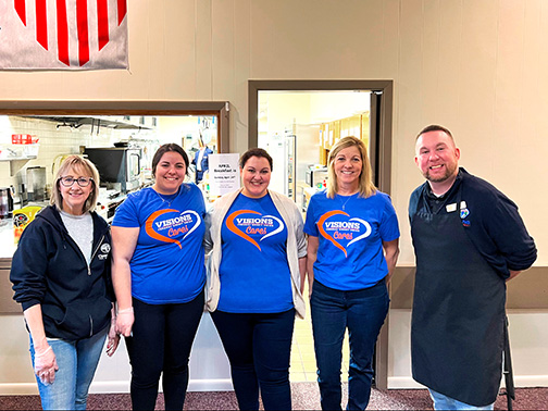 Wearing Visions Cares volunteer shirts, employees Emileigh, Jocelyn, and Karin stand smiling with representatives from Clear Path for Veterans at the Binghamton American Legion Post 1645.