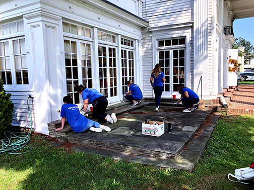 A group of Visions employees are pictured painting and weeding a section of the Endicott Visitors Center in Endicott, NY.