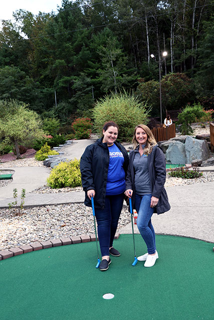With mini-golf clubs in hand, Community Development Liaison, Jocelyn, and Business Services Officer, Ashley, smile on the putting greens at Chuckster's of Vestal, NY, for the United Way Emerging Leaders Society Golf Tournament.