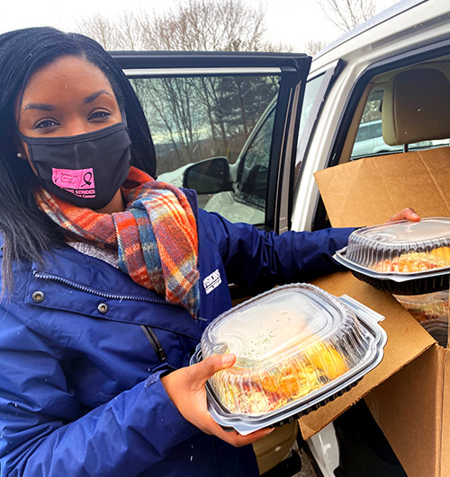 Community Development Manager, Aisha Jasper, poses with one of the 300 meals donated to frontline staff at UHS Senior Living at Ideal.
