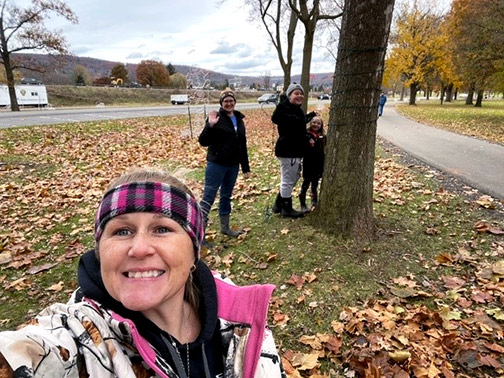 Visions employees, Andrea and Kelly are with Andrea's niece and nephew, hanging holiday lights around a tree for the Broome County Festival of Lights in Otsiningo Park.