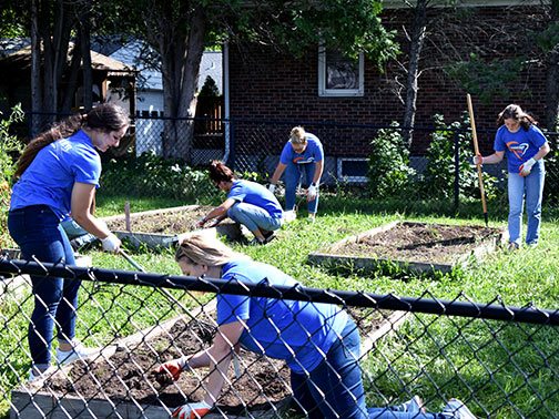 Visions high school interns are pictured pulling weeds to clean up a garden bed in preparation for winter outside the Endwell Methodist Church.