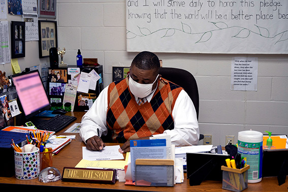 Johnson City School District employee, Mr. Wilson, works at his desk after helping Visions give away free haircuts to 40 lucky students.