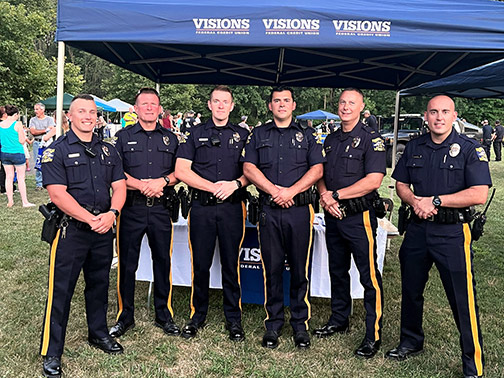 Some of the Washington Township Police officers pose in front of the Visions tent at the annual National Night Out event.