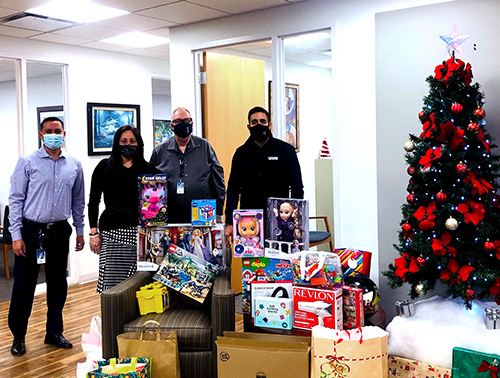 Visions FCU employees from our Saddle Brook, NJ office pose behind a large pile of toys collected for the CASA for Children of Bergen County