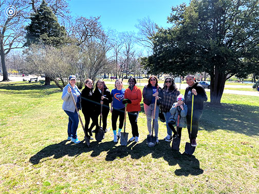 Visions employees pictured ready to plant trees in an open park on a beautiful spring day.