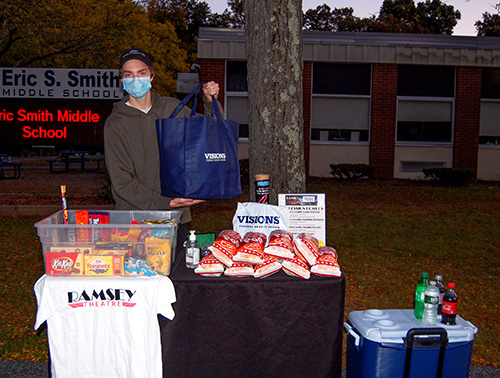 Ramsey Theatre associate, Jake Sinnaeve, operates the table of snacks and goodie bags offered to those with a complimentary ticket courtesy of Visions prior to the movie showing.