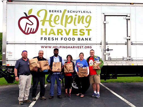 Visions FCU staff with staff from the National Association of Letter Carriers Branch 258 holding bags of food donations