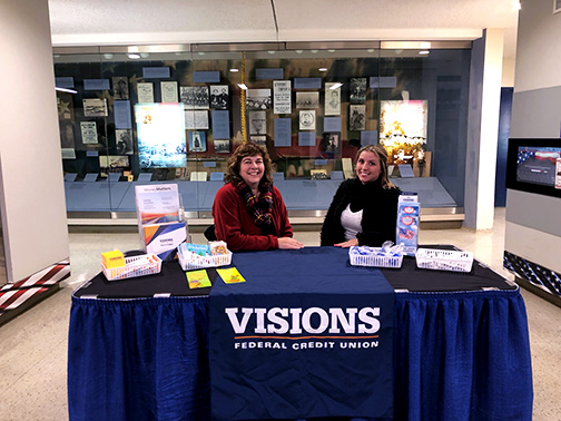 Pictured at the Visions table, braving the cold for a Syracuse Crunch hockey game, are Patti (Service and Sales Representative, Syracuse) and Cortny (Fraud Investigative Analyst).