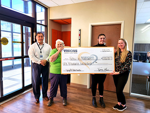 Carol (Founder of Vets in Nature) and Visions employees Jim (MBL Senior Loan Officer), Abigail (S. Member Account Specialist), and Courtney (Service and Sales Representative) holding a giant check.