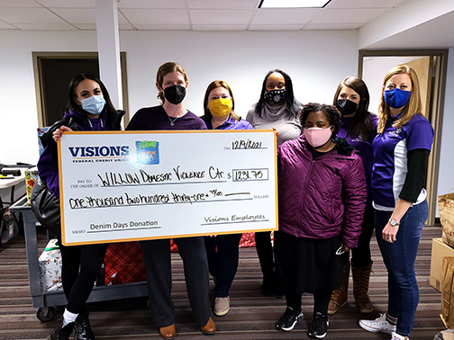 Staff from the Willow Domestic Violence Center pose with a jumbo Denim Days check from Visions for $1,231.75.