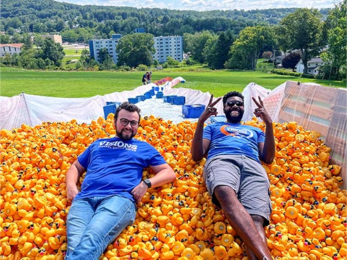 Two Visions employees lying on a large pile of rubber ducks at the top of the racecourse put together by the Broome County Humane Society.