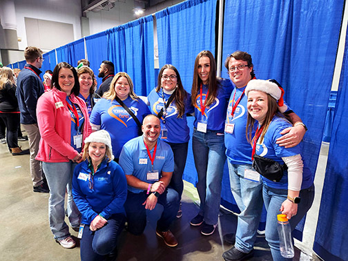 The smiling Visions volunteer team at the Syracuse Christmas Bureau, ready to help spread holiday cheer!