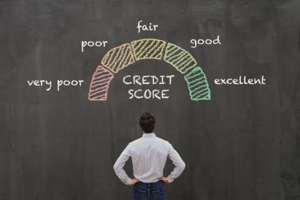 person looking at credit score range on chalkboard