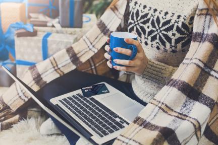 woman shopping online for holiday gifts using her Visions Visa Elite Signature® credit card
