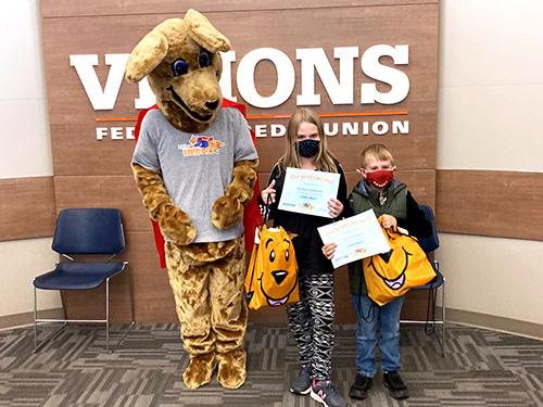 Amelya and Blaine posing with Kirby Kangaroo with their Little Heroes certificate and gifts from Visions