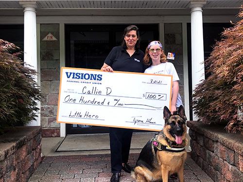Calle pictured with Visions FCU Branch Manager of the Randolph, NJ office, Jeanne. They are holding a large check for $100.