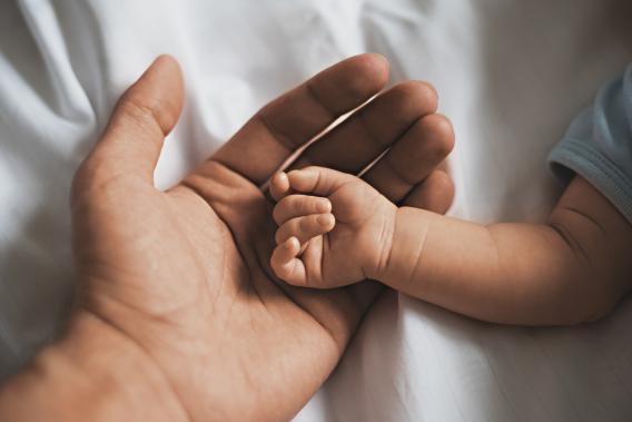 baby's hand on top of father's hand