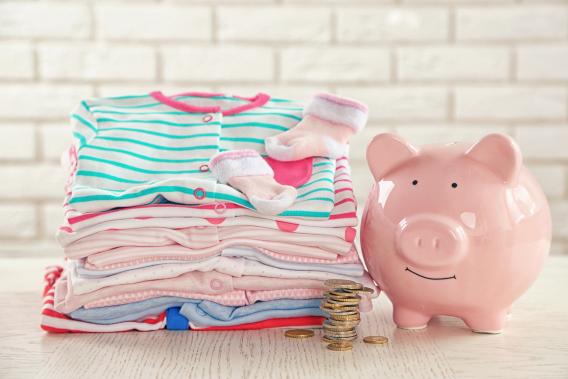 piggy bank next to baby clothes