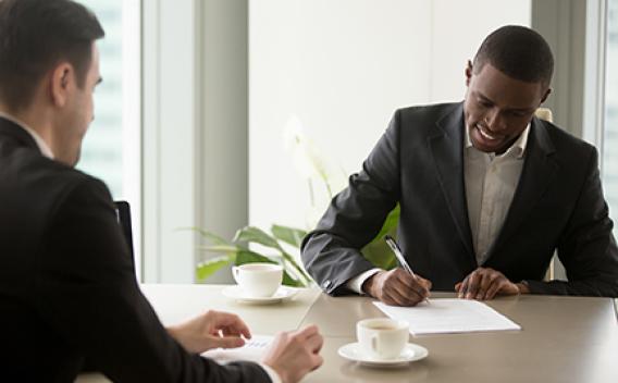 Two business people signing documents