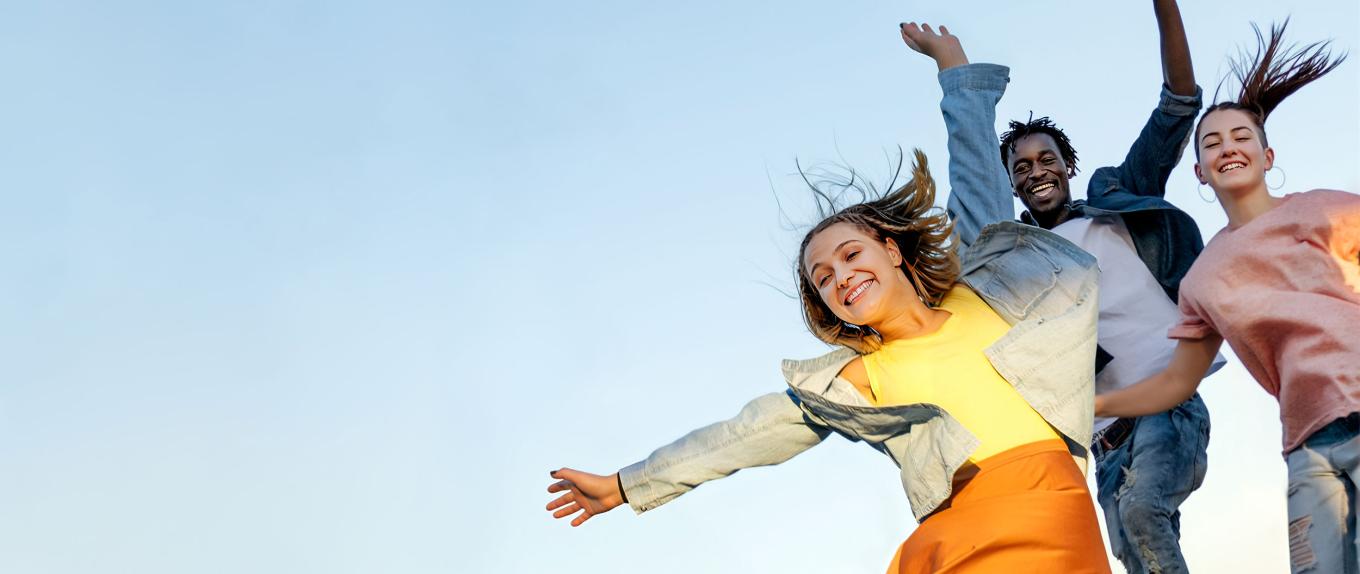 Image of three kids jumping with a blue sky background
