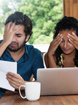Man and woman who look stressed over a bill